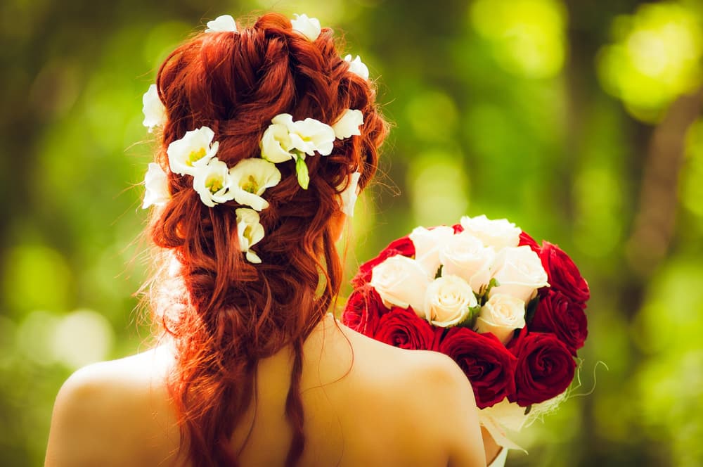 Chignon de mariée bohème orné de fleurs blanches